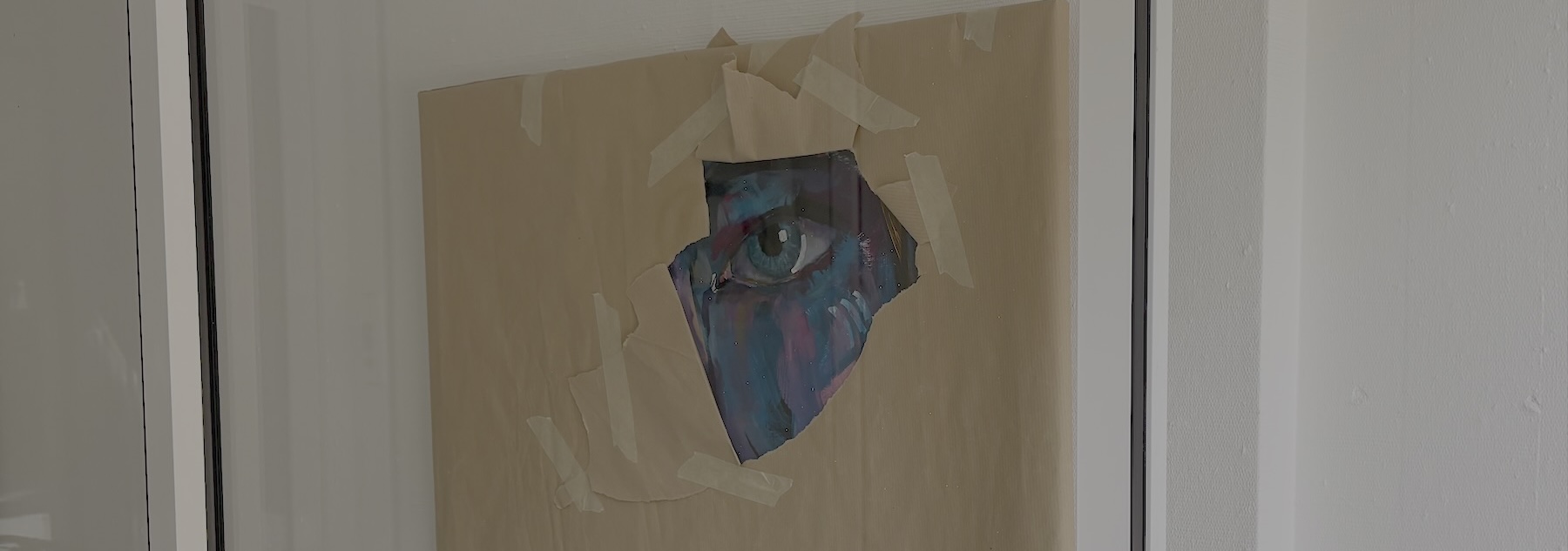 Ausschnitt eines mit Paket verdeckten Gemäldes, ein Auge schaut heraus.